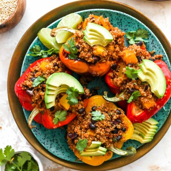 Quinoa and black bean stuffed peppers on a plate with toppings