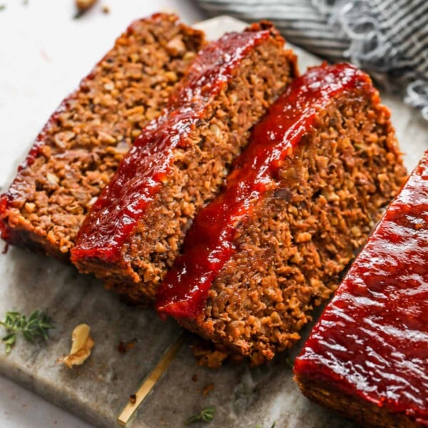 Three slices of vegan meatloaf on a cutting board