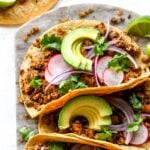 Vegan chorizo tacos topped with avocado and cilantro