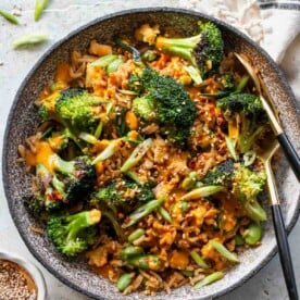 Broccoli fried rice in a grey bowl with sauce drizzled overtop