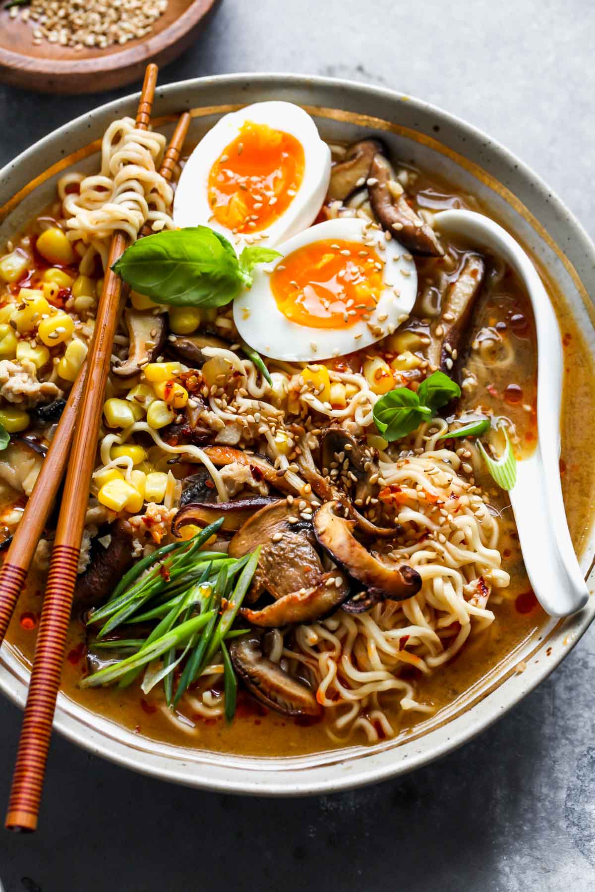 Homemade ramen recipe styled in a bowl with a spoon and garnishes