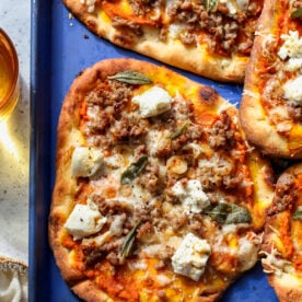 Autumn pizza arranged on a blue baking sheet.
