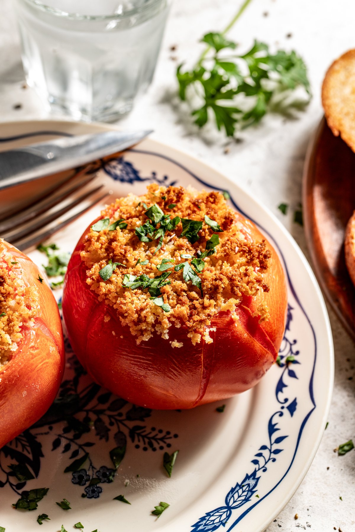 Baked Stuffed Tomato styled on a white and blue plate.
