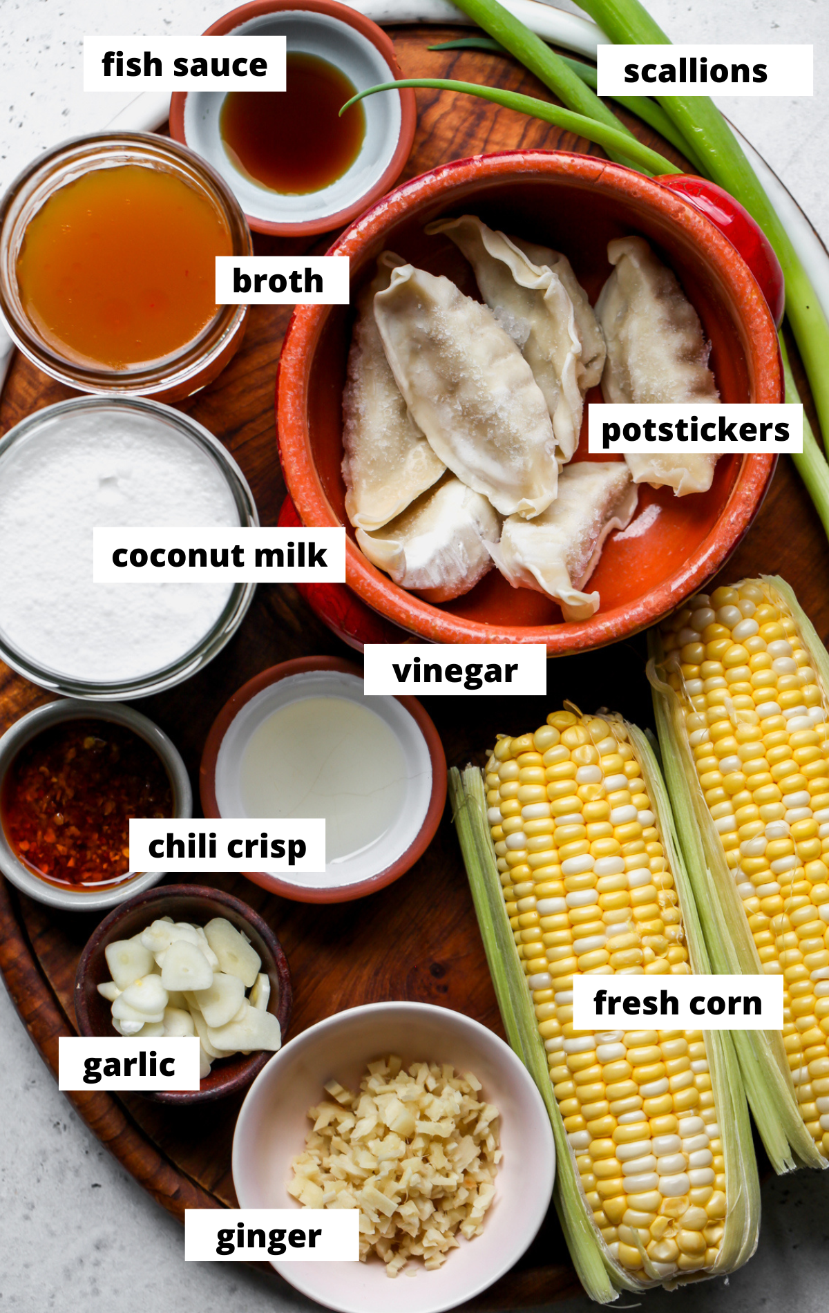 Recipe ingredients in separate bowls arranged on a wooden platter with labels.