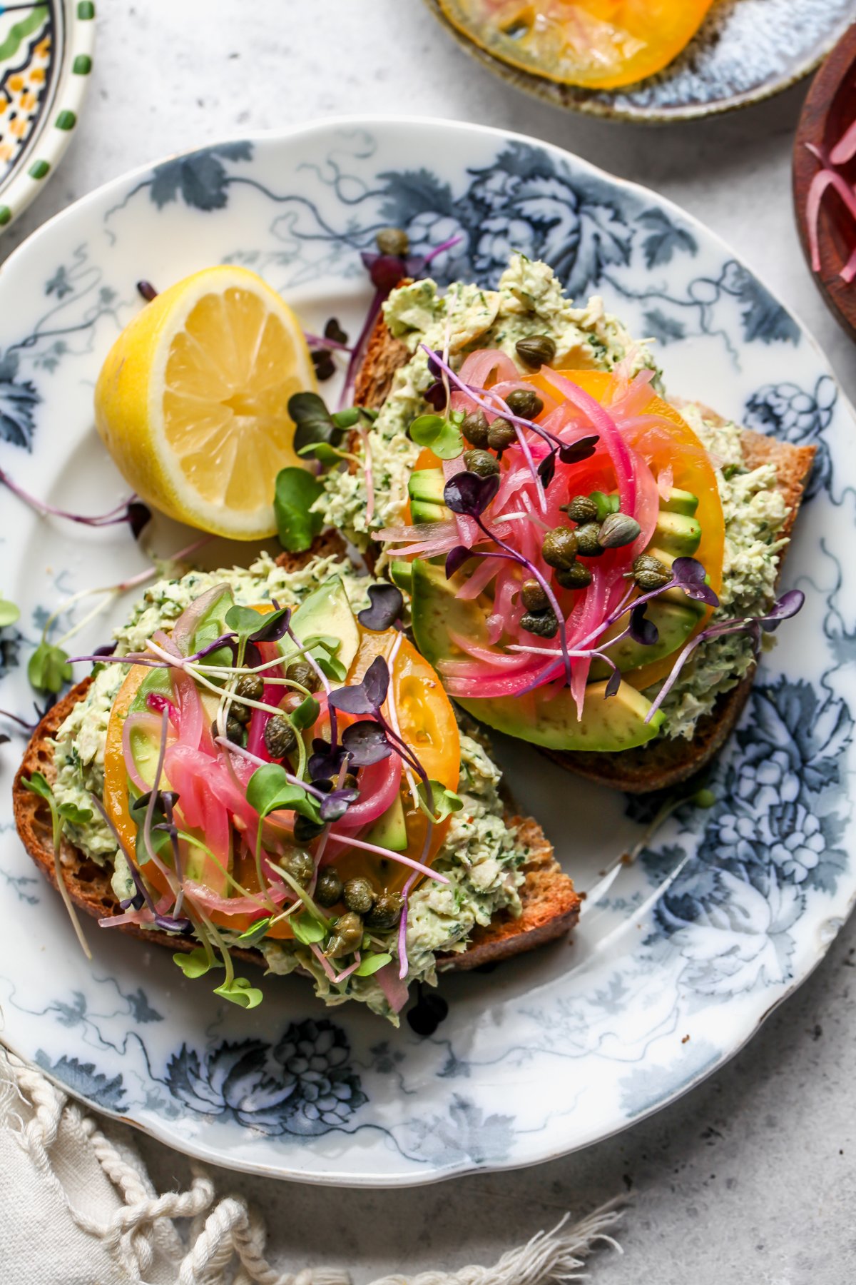Green Goddess Chicken Salad toast arranged on a white and blue floral plate.