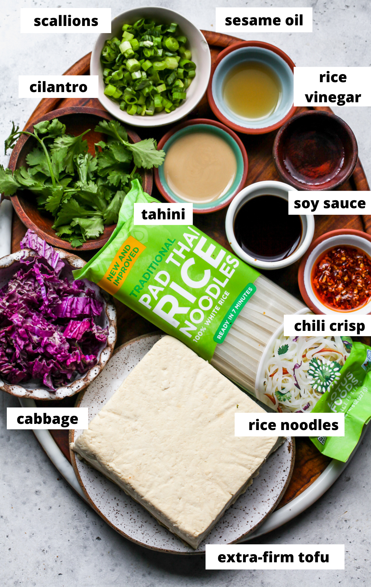 Recipe ingredients in separate bowls arranged on a wooden board with labels.