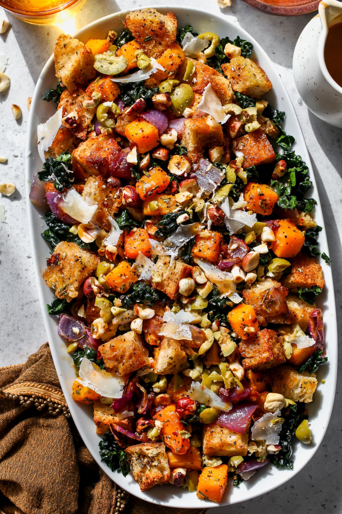 Autumn Panzanella Salad styled on a white serving platter on a gray surface.
