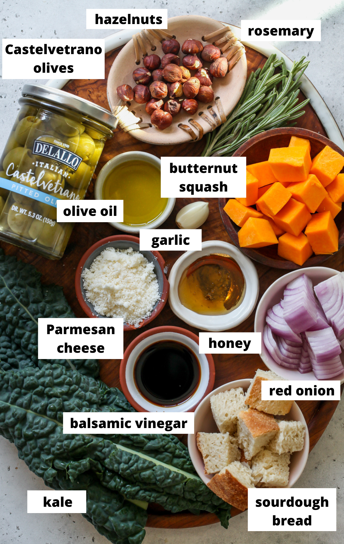 Recipe ingredients in separate bowls arranged on a wooden platter with labels.