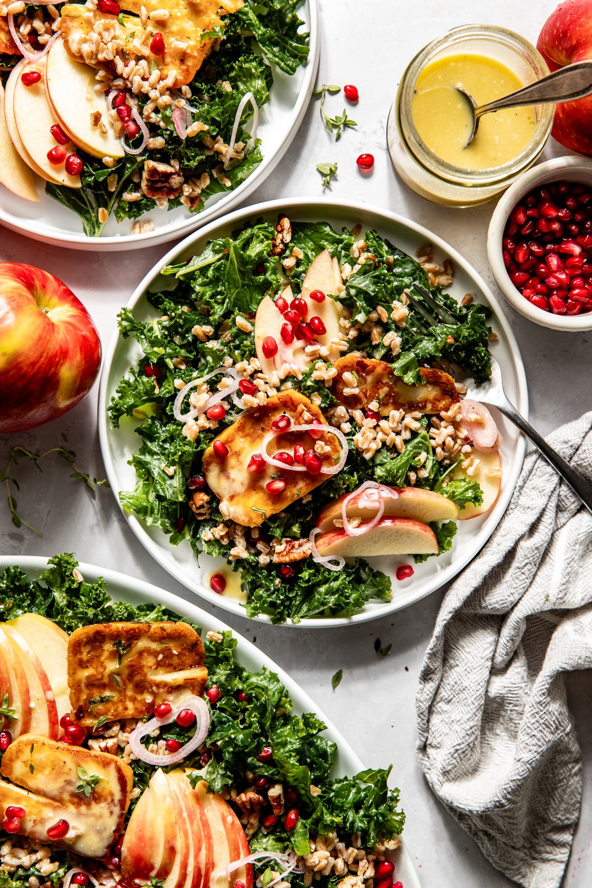 A portion of Honeycrisp and halloumi salad on a white serving plate styled on a light gray surface.