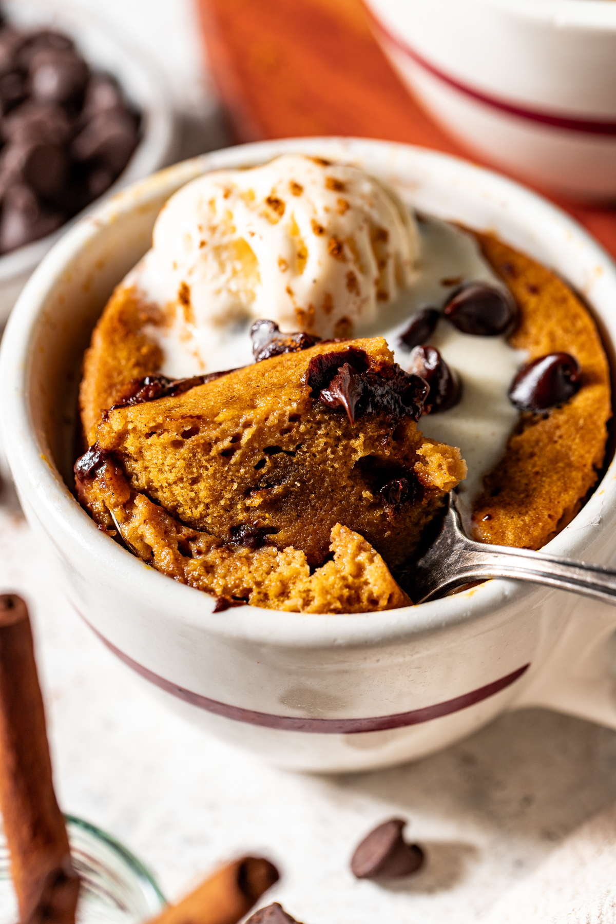 A spoon lifting a chunk out of a pumpkin mug cake.