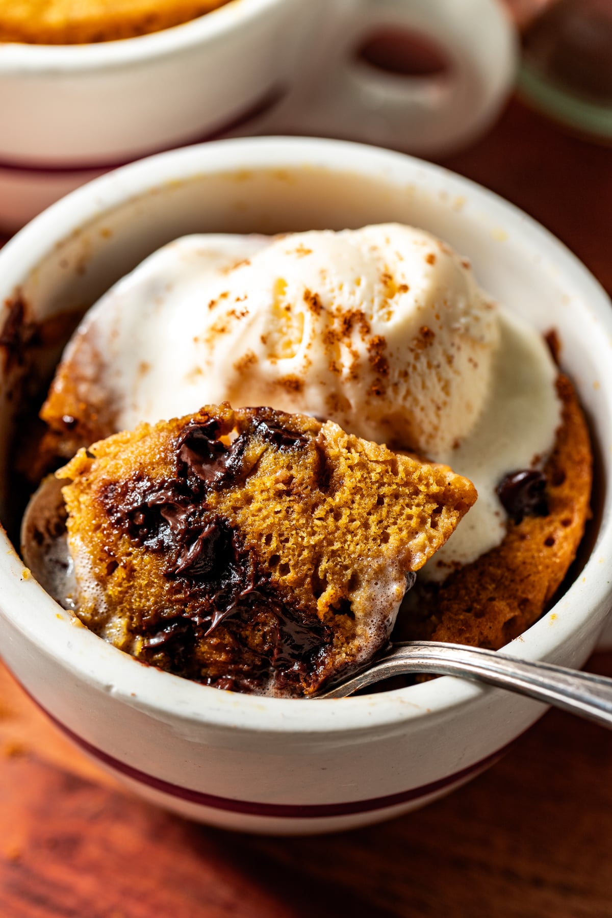 A bite of cake being lifted with a silver spoon to show inside texture of cake.
