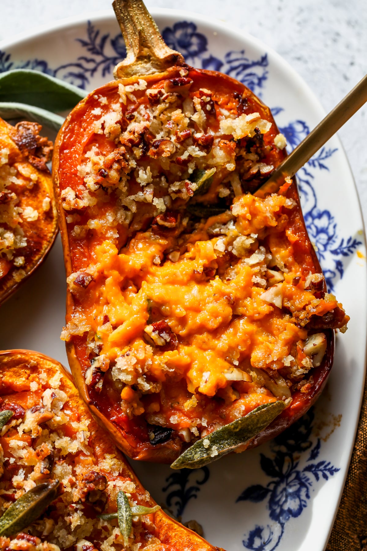 A spoon digging into the filling of a twice-baked honeynut squash boat.