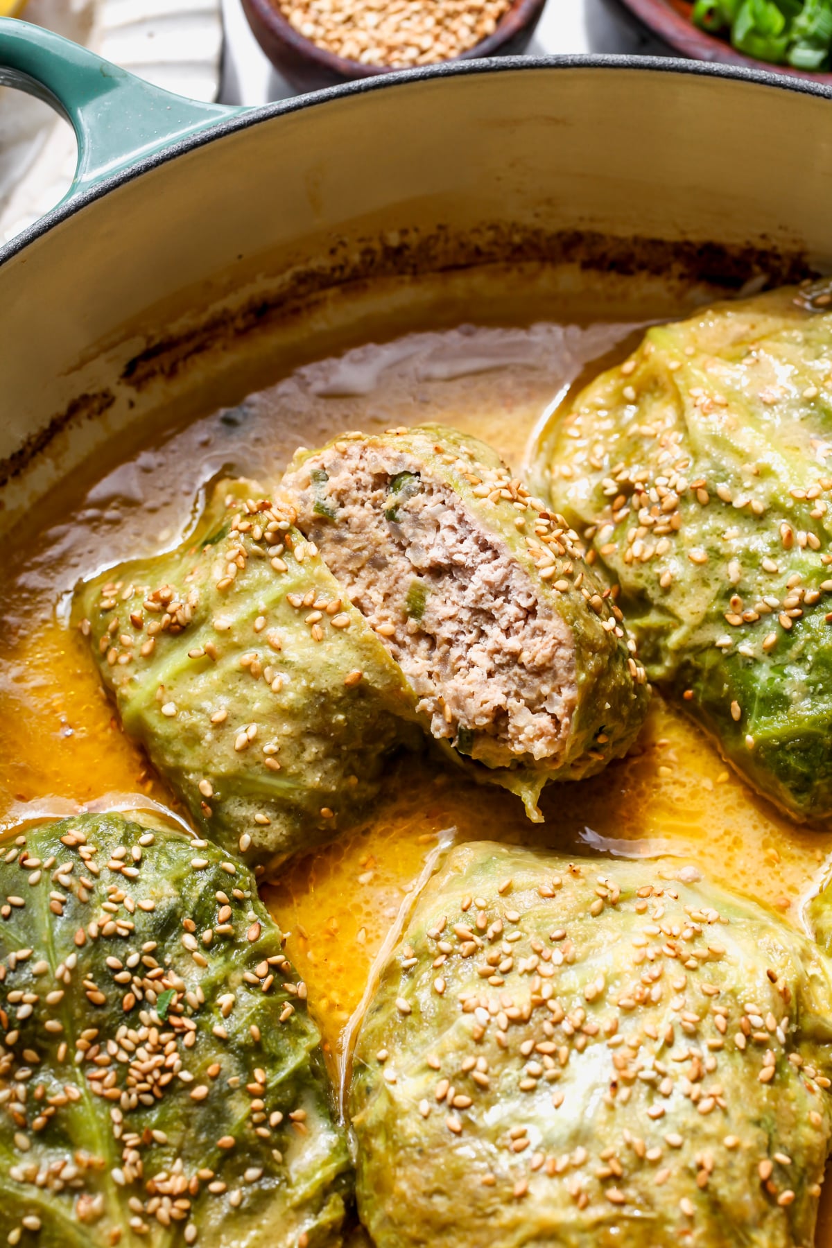 Miso Butter Braised Cabbage Rolls sliced in half in a sauté pan.