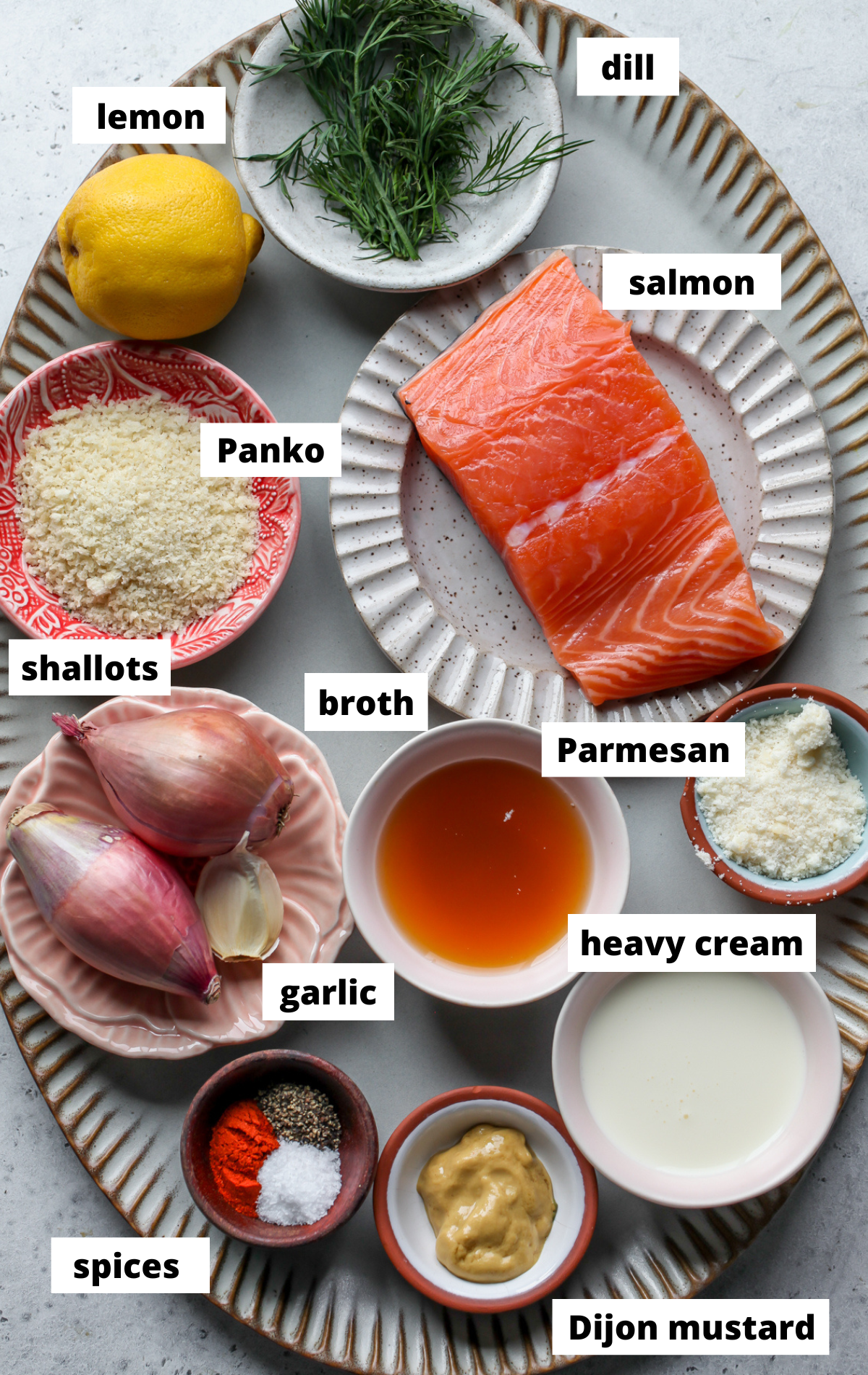 Recipe ingredients in separate bowls arranged on a scalloped platter with labels.