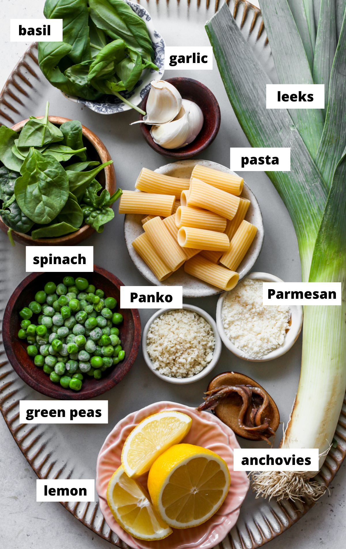 Recipe ingredients in separate bowls arranged on a scalloped tray with labels.