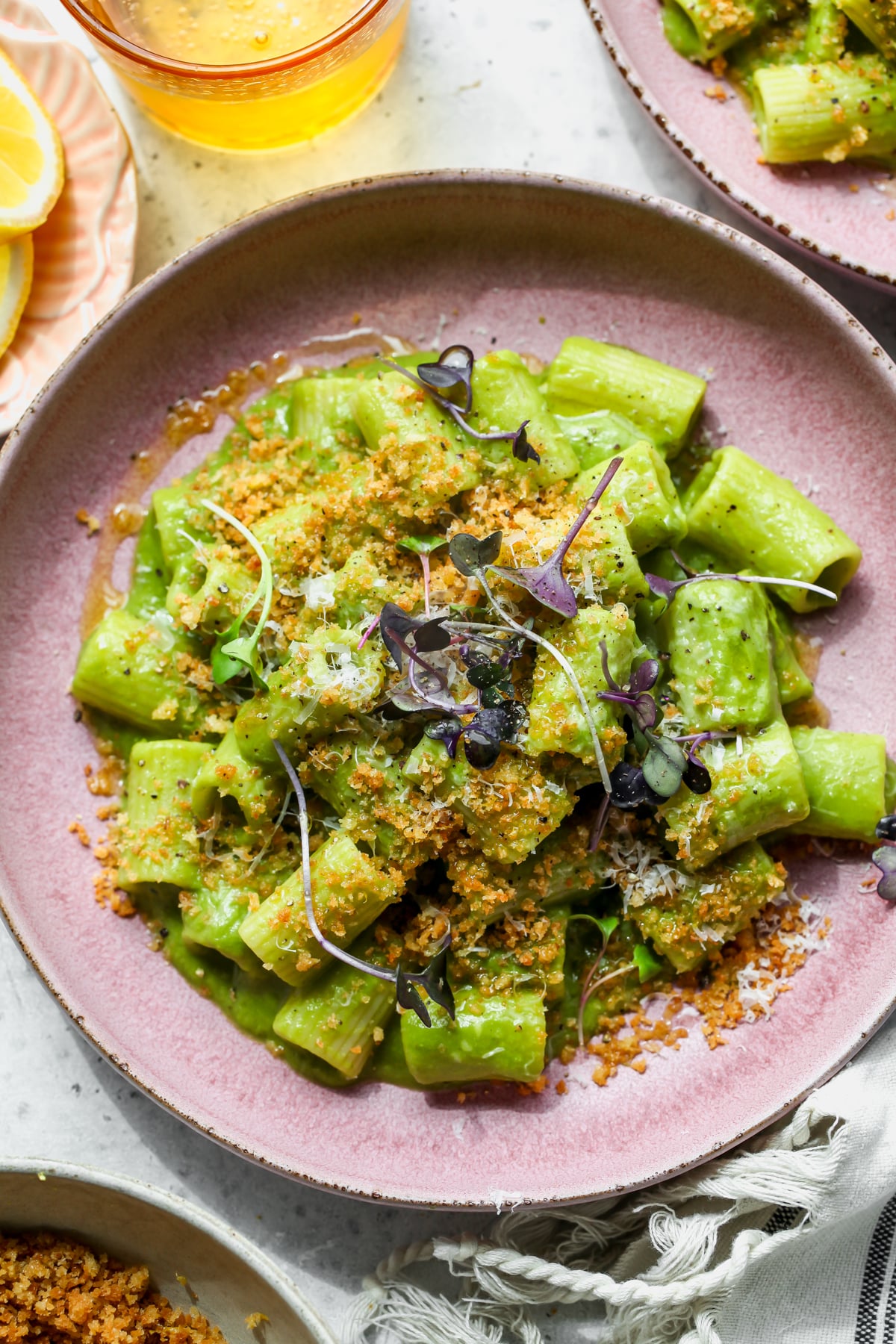 Creamy Caramelized Leek Pasta styled in a pink serving bowl topped with Parmesan and anchovy breadcrumbs.