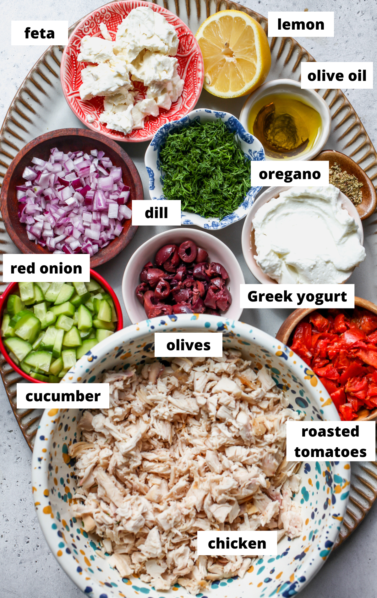 Recipe ingredients in separate bowls arranged on a scalloped tray with labels.