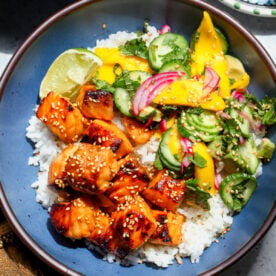 Hot Honey Salmon with Mango Salad and coconut-lime rice styled in a blue bowl.