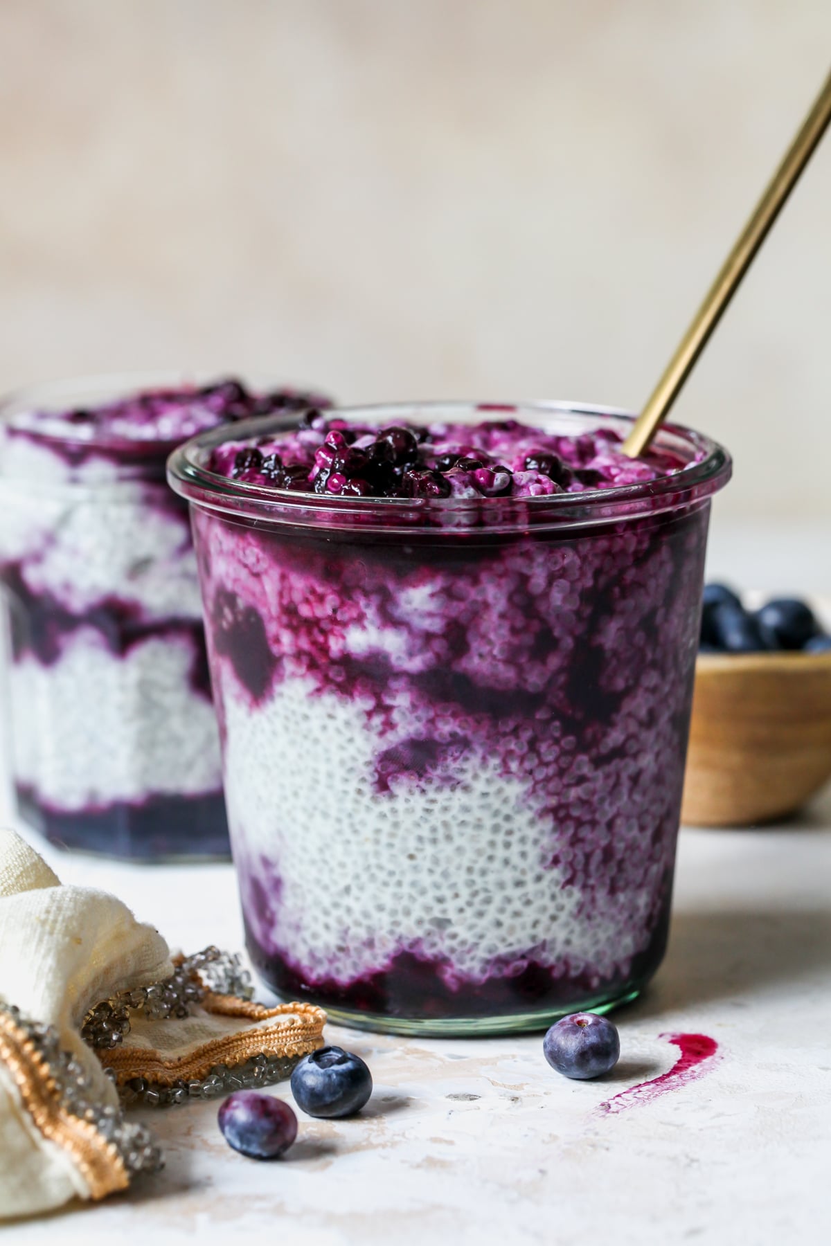 Earl Grey Chia Pudding with Wild Blueberry Compote styled in a clear glass jar.