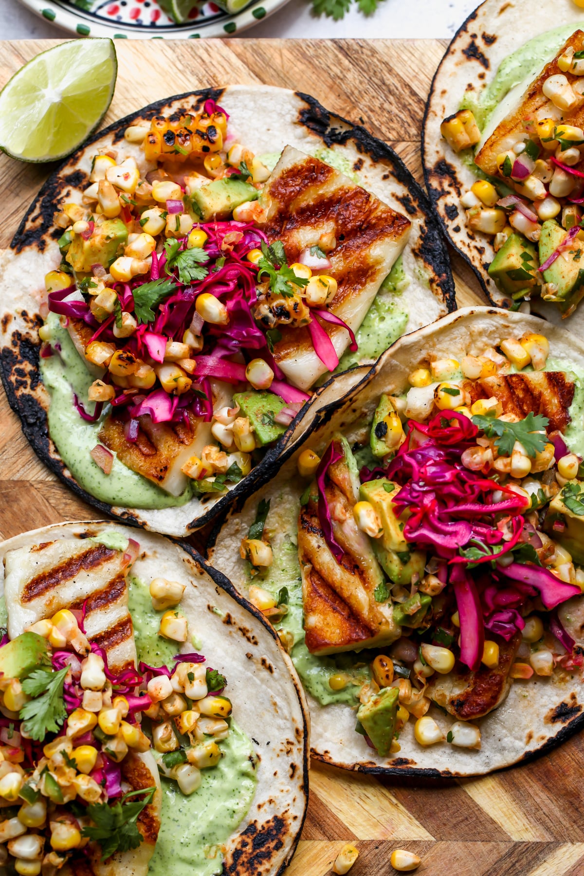 Grilled Halloumi and Corn Tacos styled on a wooden cutting board.