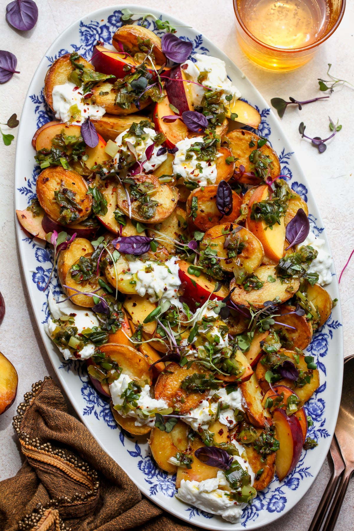 mayo-less potato salad styled on a large oval platter on a light colored surface.