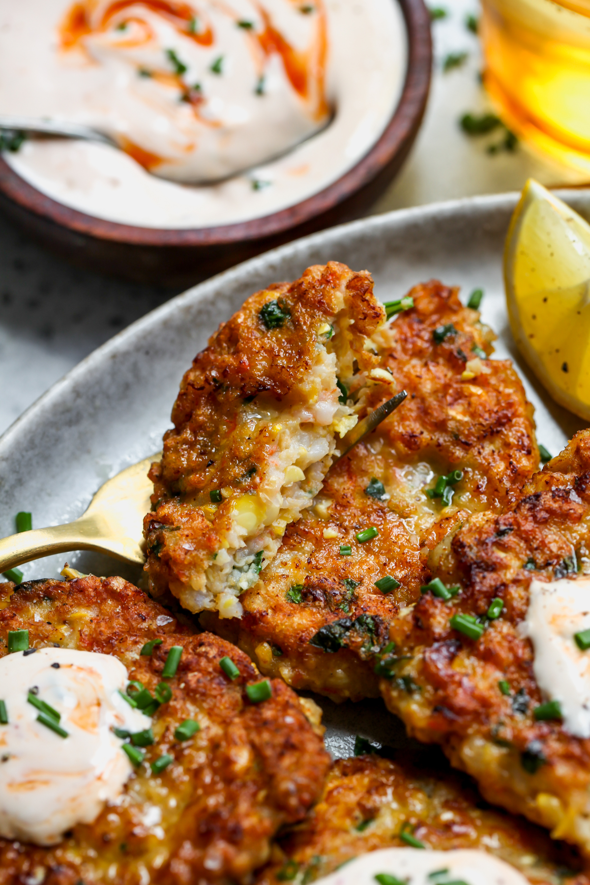 A fork slicing into a shrimp cake to show inside texture.