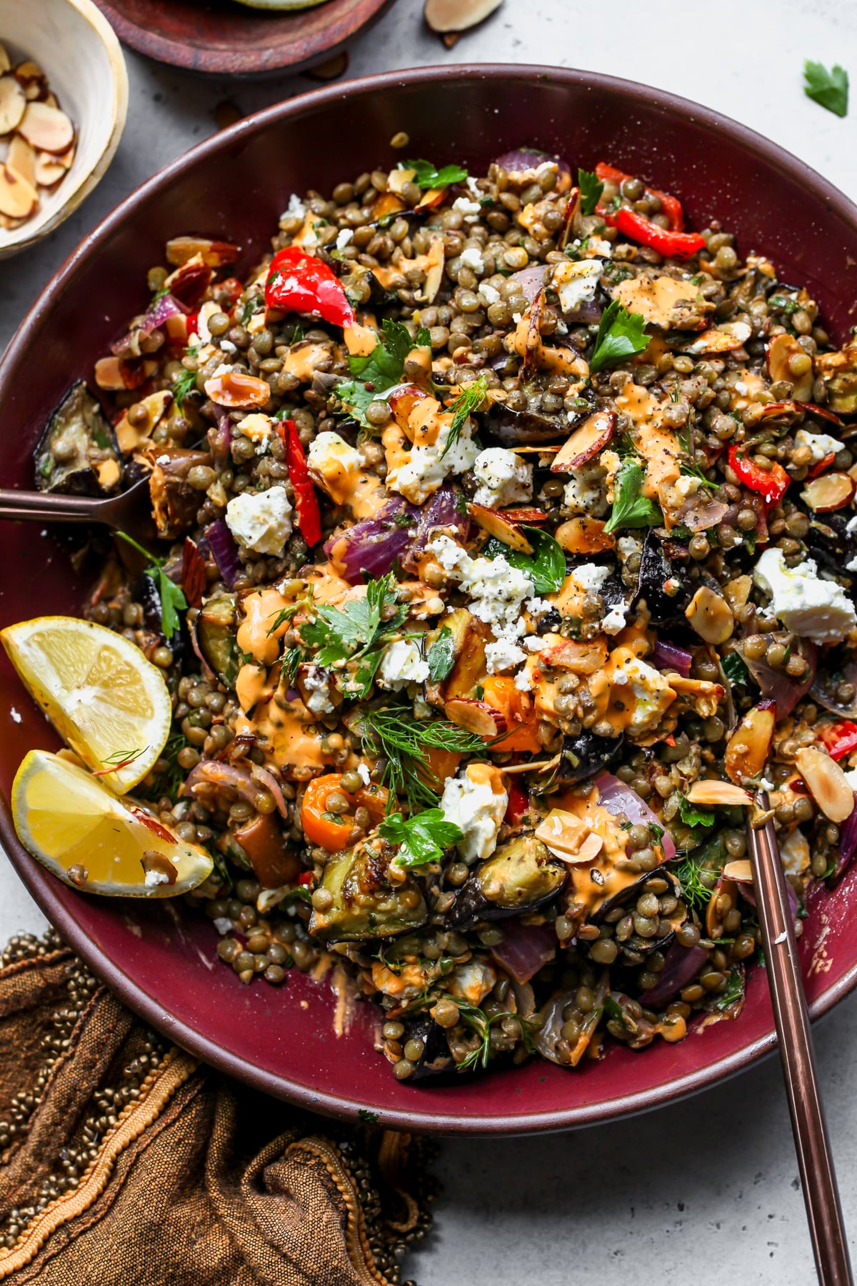 Lemony Lentil and Roasted Eggplant Salad styled in a large maroon serving bowl.