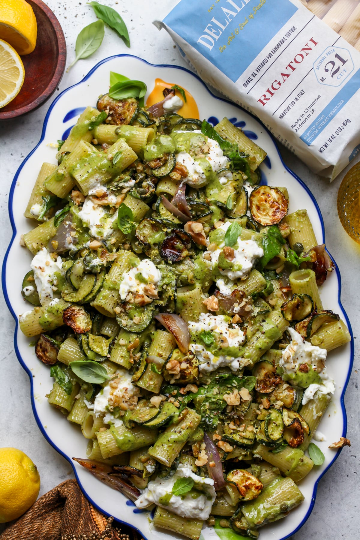 Roasted Zucchini Pasta Salad on a platter next to a bag of DeLallo rigatoni pasta.