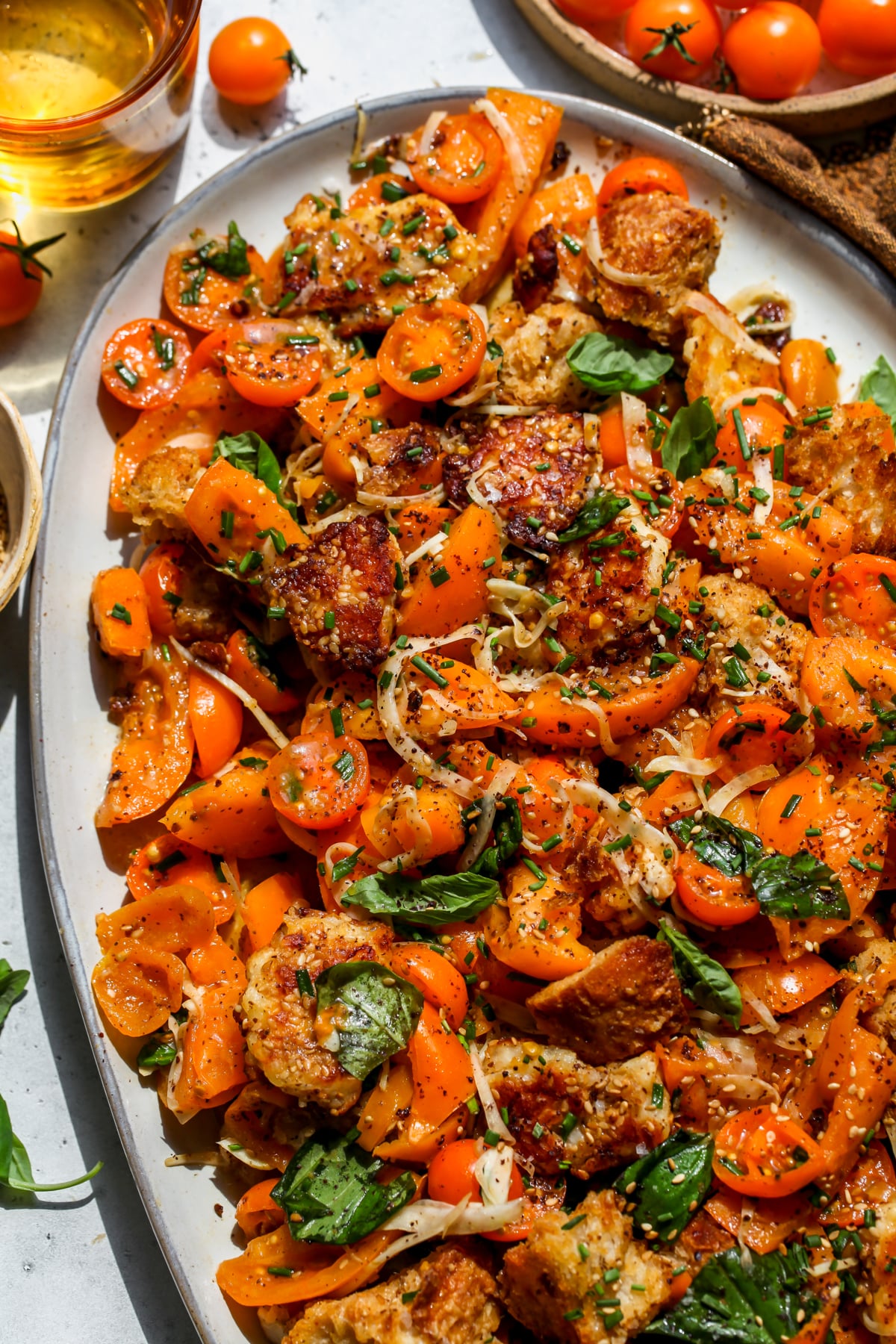 Sungold Tomato Panzanella with Halloumi and sourdough bread styled on a large platter.