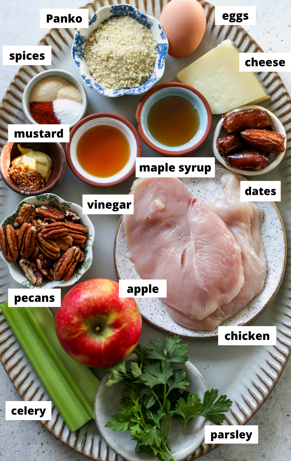 Recipe ingredients in separate bowls arranged on a large scalloped tray with labels.