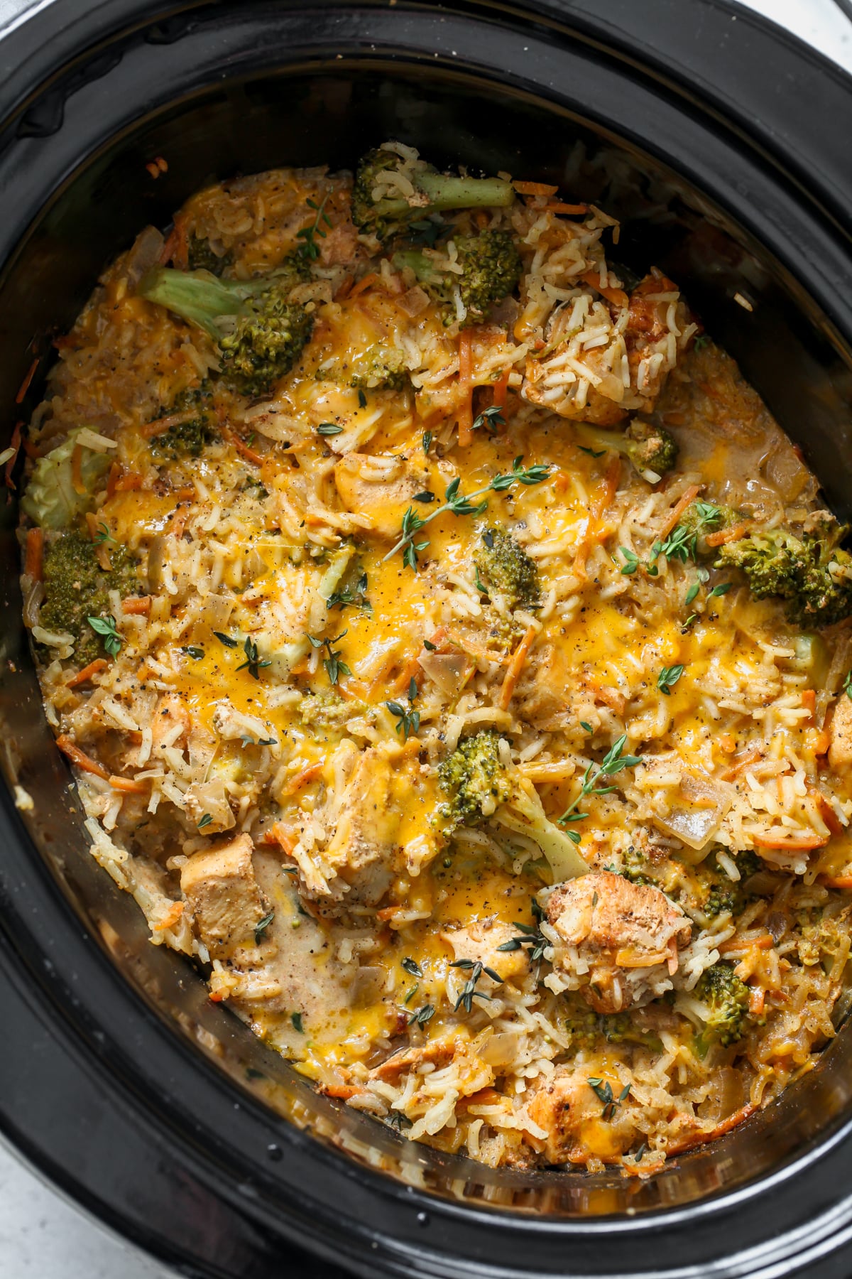 Slow Cooker Broccoli-Cheddar Chicken and Rice in a black slow cooker.